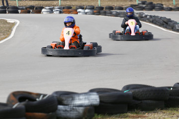 girl is driving Go-kart car with speed in a playground racing track.