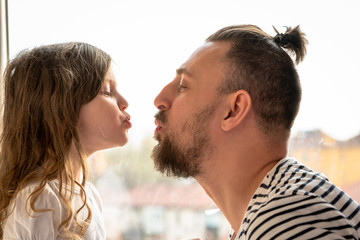 father and little daughter kissing