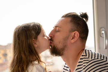 father and little daughter kissing
