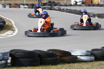 girl is driving Go-kart car with speed in a playground racing track.