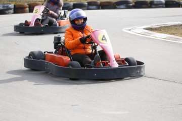 girl is driving Go-kart car with speed in a playground racing track. - obrazy, fototapety, plakaty
