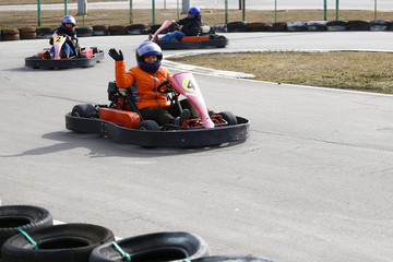 Obraz premium girl is driving Go-kart car with speed in a playground racing track.