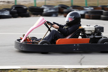 boy is driving Go-kart car with speed in a playground racing track.