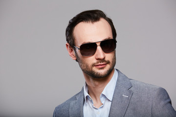 Studio portrait of handsome elegant young man in grey jacket