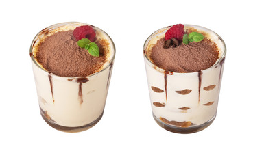 tiramisu in a glass with berries, mint and coffee beans on a light wooden background