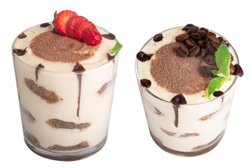 tiramisu in a glass with berries, mint and coffee beans on a light wooden background