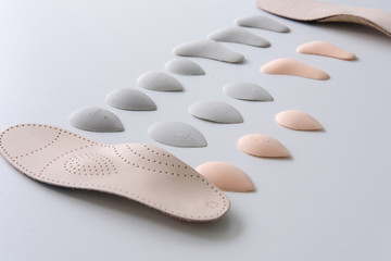 The process of manufacturing individual orthopedic insoles for people with foot diseases, flat feet. Close-up of the insole and accessories for it.