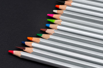 Naklejka premium gray wooden pencils with colored rods on a black background