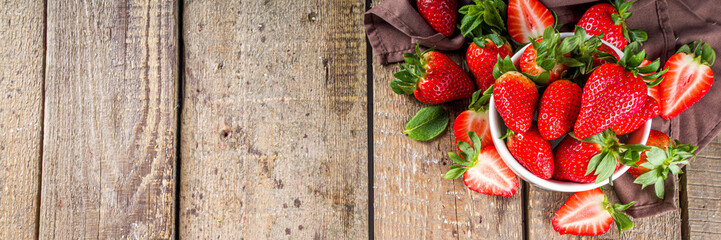 Heap of fresh organic strawberries in ceramic bowl on rustic wooden background? copy space