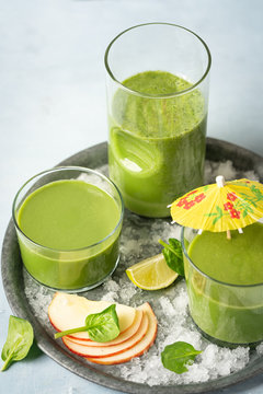 Green smoothie in glass with organic ingredients, vegetables on a light background with copy space. Selective focus. Food and drink, healthy dieting, nutrition, alkaline, vegan, vegetarian concept.
