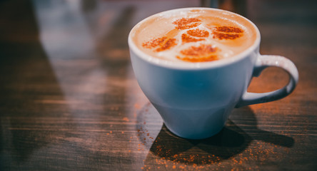 Cup of hot latte art coffee on bar counter in cafe