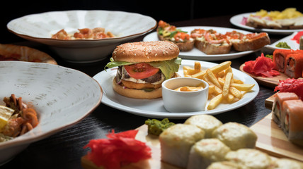 hamburgers in a cafe in a composition with pizza, salad, potatoes