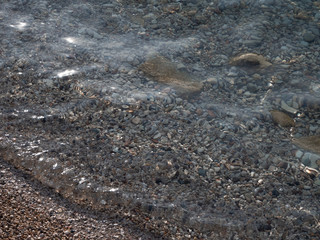 Transparent water on the pebble beach