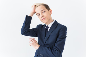 Portrait of stylish school boy teenager in white shirt and jacket against white background.