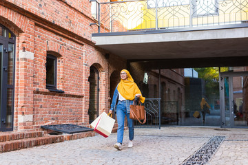 Sale and buying concept - Happy arab muslim girl with shopping bags after mall
