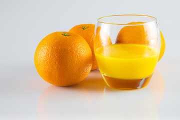 Szkło z sokiem z pomarańczy, świeże pomarańcze.