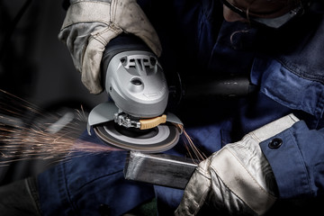 Close up on a man hold an angle grinder with sparks