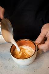 bartender is preparing a cappuccino in a cafe