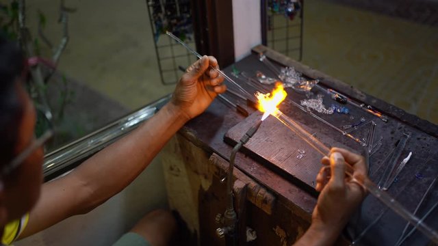 Senior man forming melted glass