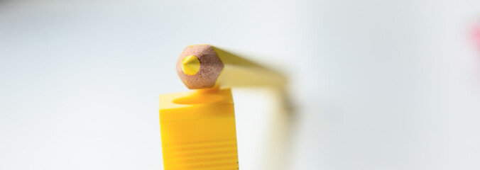 a yellow pencil lies on a yellow sharpener. Concept - school, education, art education, office, indicate the way.  Copy space