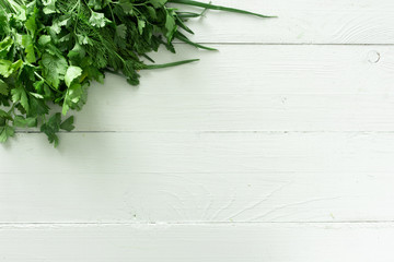 Set of greens for salad on a white wooden background. Place for text.