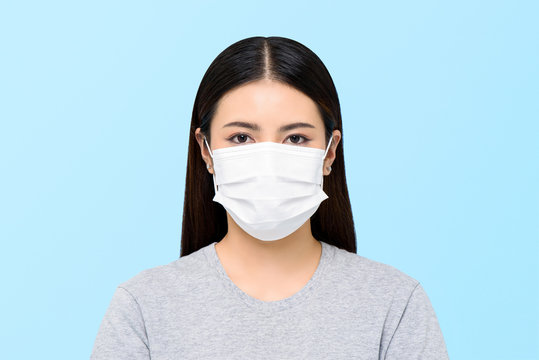 Asian woman wearing medical face mask isolated on light blue background