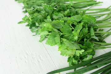 Set of greens for salad on a white wooden background. Place for text.