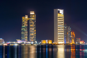 Fototapeta na wymiar Night view of Abu Dhabi modern skyscrapers panorama. Luxury lifestyle hotels and business centers of United Arab Emirates.