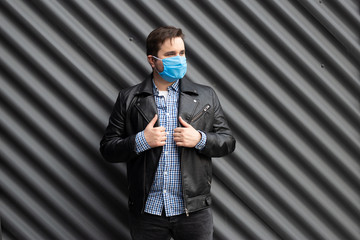 Fototapeta premium Man in medical mask on the background of black wall