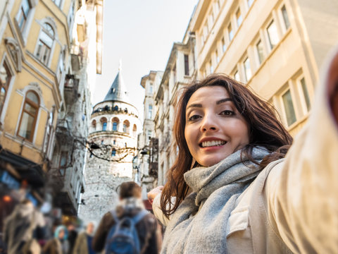 Beautiful woman takes selfie with Galata tower