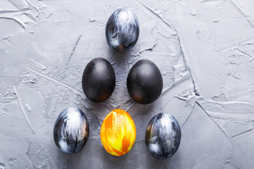 Holidays, traditions and Easter concept - Dark stylish easter eggs on grey background.
