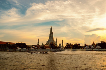 Fototapeta premium boat sailing in the middle of the Chao Phraya River and Wat Arun, Bangkok