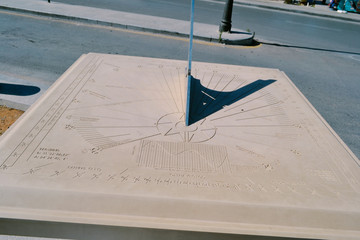Vintage sundial throws a long shadow, tracking motion of sun telling time of day