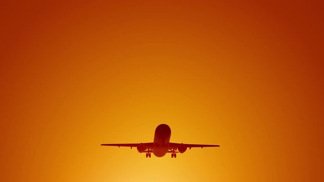 A large passenger plane takes off against the background of a sunset. Orange backgrand..Super slow motion.