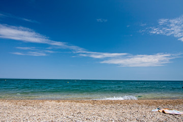 Bathers towels laid out on a beach by the Mediterranean sea