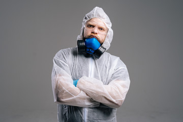 Serious epidemiologist medical worker in protective coveralls, glasses and respirator. Concept of Coronavirus COVID-19 Pandemic. Studio shot on isolated dark background.