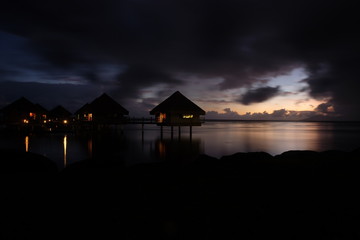 Fototapeta premium A silhouette of a beach house during a beautiful coastline sunset.