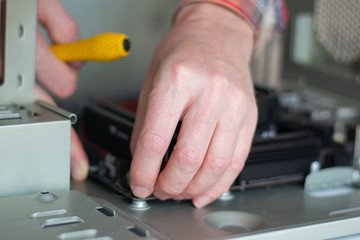 Installing a new motherboard in the system unit. Computer repair and upgrade. Close-up of the hands of a master repairing a computer. selective focus