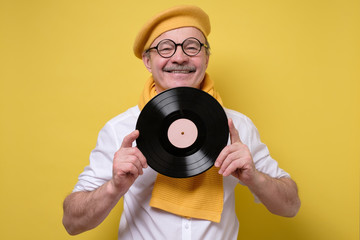 Cheerful man holds the vinyl in hand