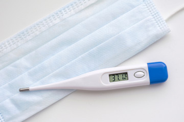Thermometer with temperature numbers 37.1 on a medical mask in blue on a white background. Coronavirus Precautions Mask Protection.