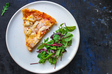 slice pizza and salad leaves in a plate on the table (tasty snack) menu concept background. top view. copy space for text