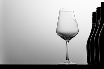 Broken glass of wine, wine bottles