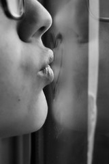 Mujer enviando un beso a través de la ventana, foto en blanco y negro