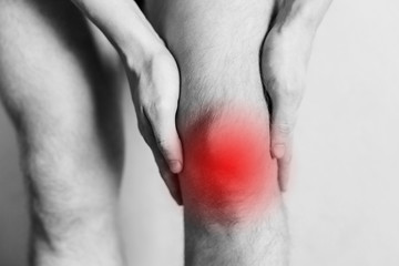  Joint injuries, fatigue at work. Area of the injury, the image on a clean background. Spasm on the man's knee.