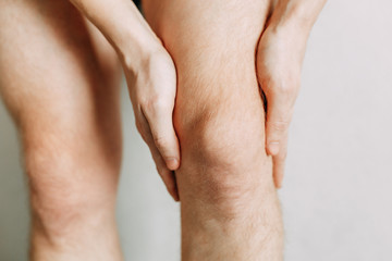  Joint injuries, fatigue at work. Area of the injury, the image on a clean background. Spasm on the man's knee.