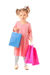 Cute little girl with shopping bags on white background