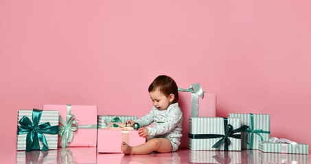 baby girl sitting on the floor with gift box
