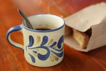 Hot coffee with smoke served with bakery on the wooden table, selective focus and free space for text.