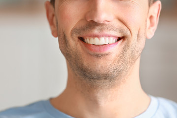 Handsome young man with healthy teeth at home, closeup