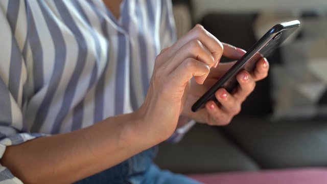 Woman's hand using smartphone and finger wiping on display